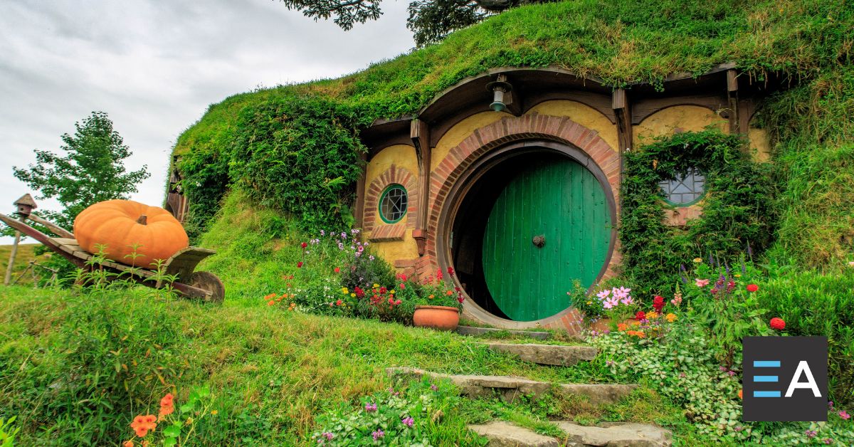 A circular hobbit door under a green hill